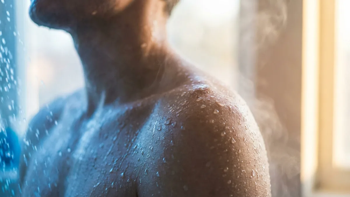 Close-up of cold shower water with blue tones, refreshing wellness concept